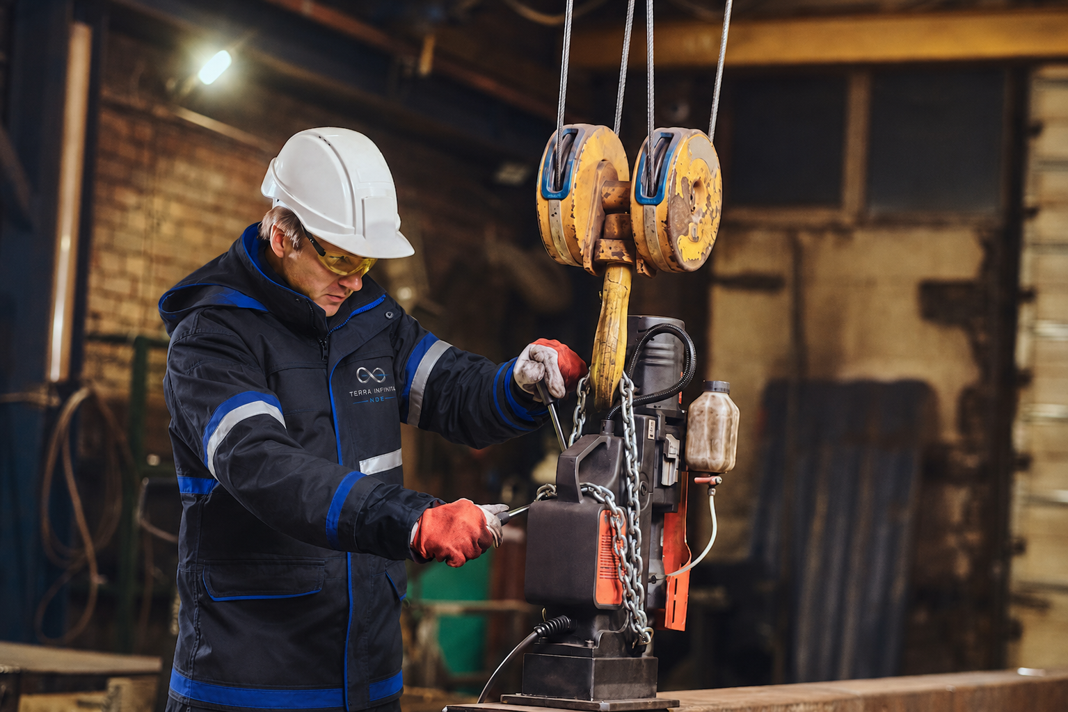 TerraInfinita technician inspecting industrial lifting machinery