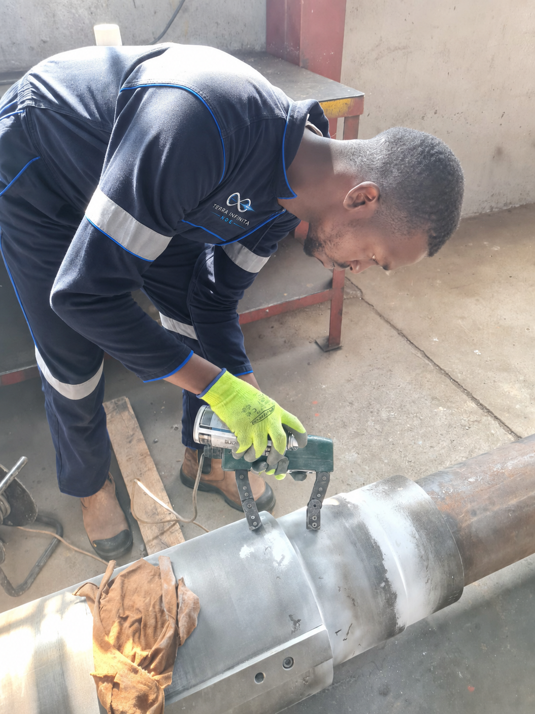 TerraInfinita NDE technician using a magnetic yoke to inspect a pipe weld