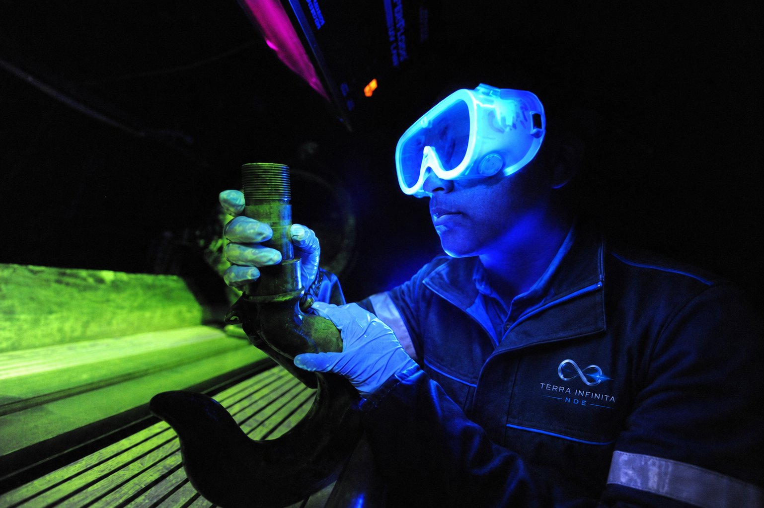 TerraInfinita technician examining a component under ultraviolet light